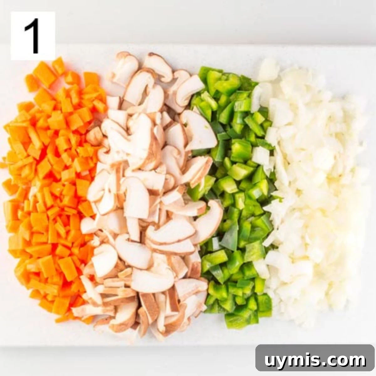 Quick Spicy Silken Tofu Recipe with Garlic Chili Sauce 4 Small dice chopped carrots, peppers and onions, and sliced mushrooms, on a chopping board.