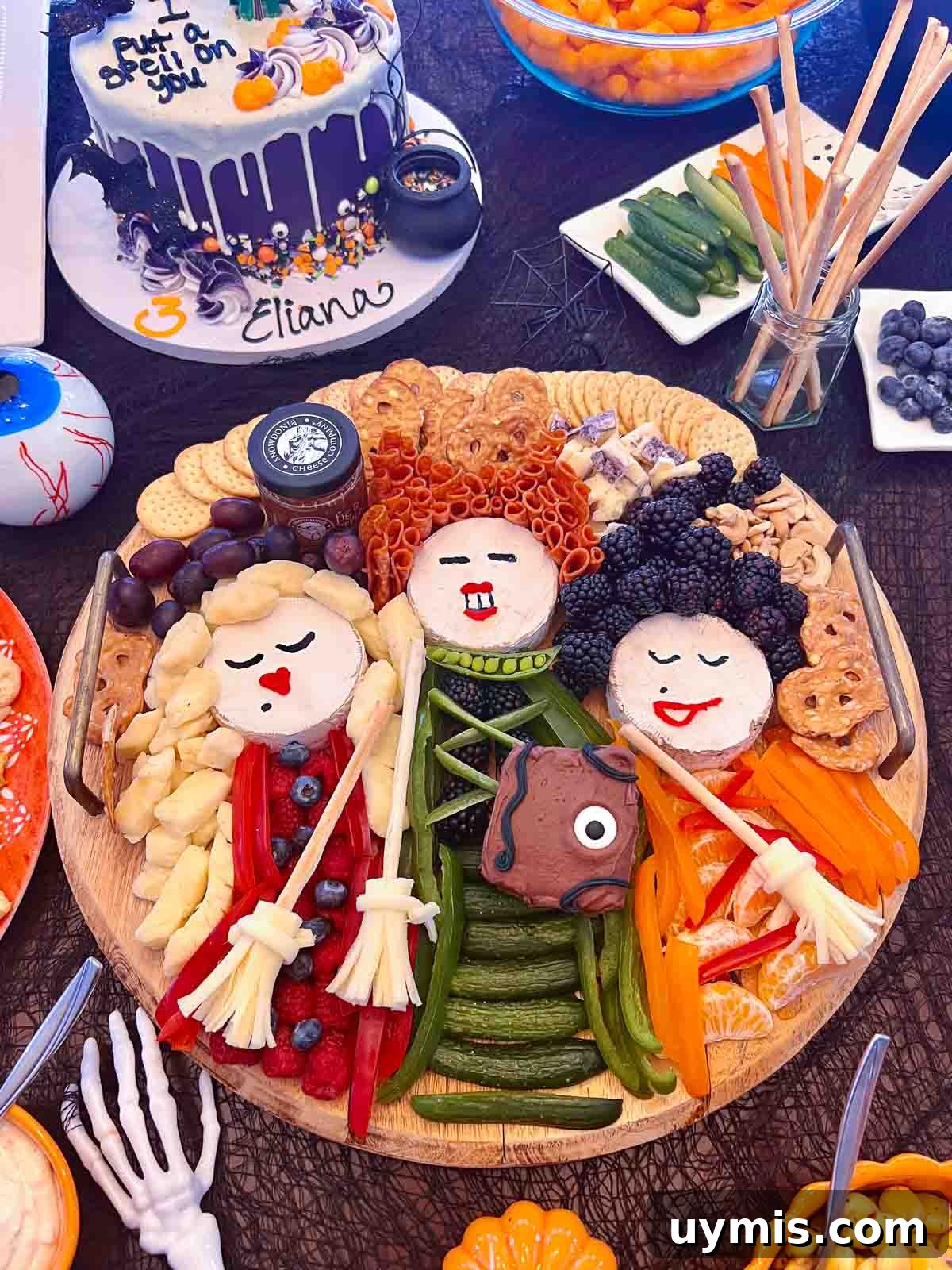 Sanderson Sisters Snack Board for a Hocus Pocus Party 6 up close view of sanderson sisters charcuterie board hocus pocus halloween party food with winifred cake