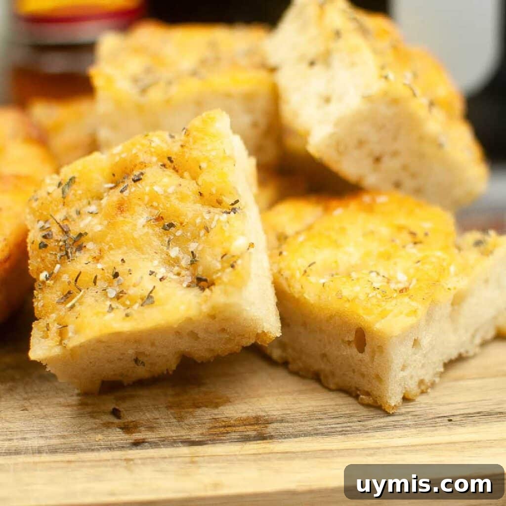 Crispy Air Fryer Focaccia Bread Recipe 2 Front close up of air fryer Focaccia bread cut into squares and stacked on a cutting board.
