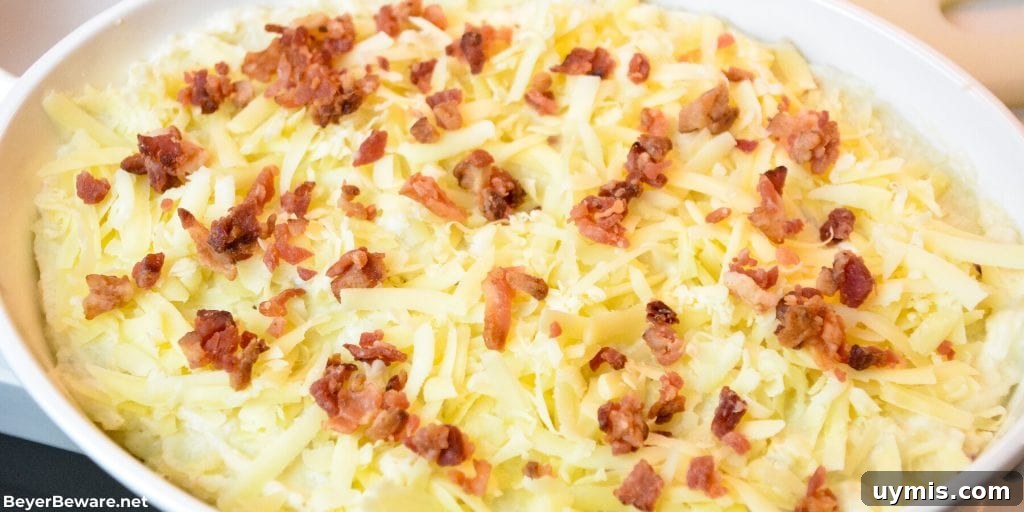 Loaded Keto Mashed Cauliflower Casserole 7 Keto loaded mashed cauliflower casserole is loaded with white cheddar cheese and bacon while made smooth as mashed potatoes with sour cream and cream cheese as it bakes to perfection.