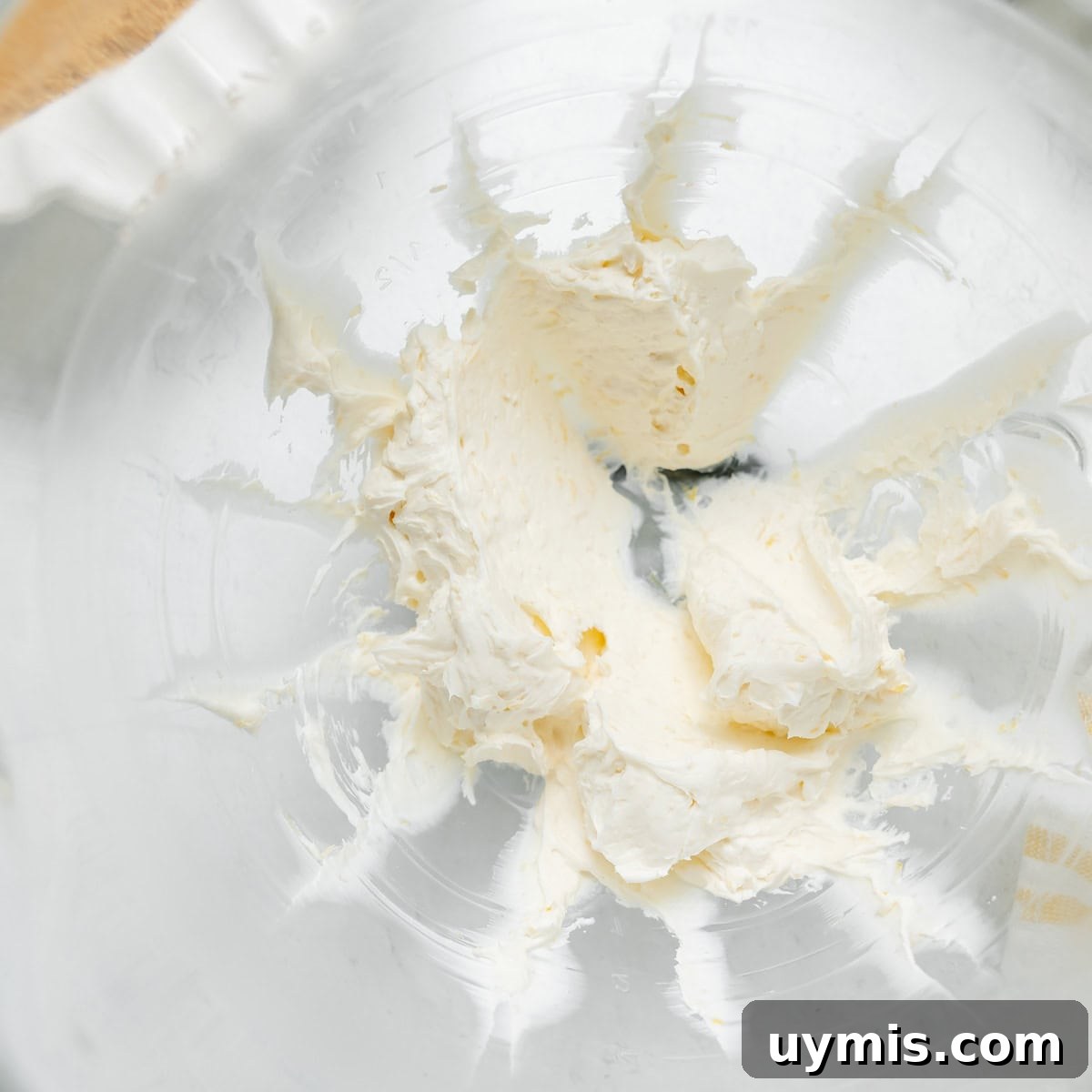 Lemon Icebox Pie Recipe with Creamy No Bake Filling 4 A glass mixing bowl with remnants of whipped cream cheese spread around the sides.