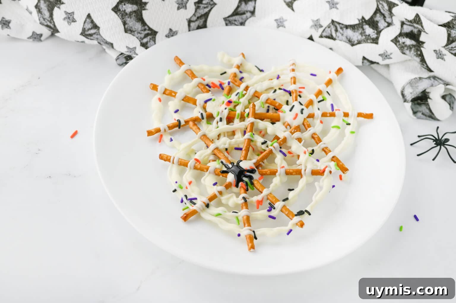 How to Make Spider Web Pretzels for Halloween 3 spider web pretzels on a round white plate