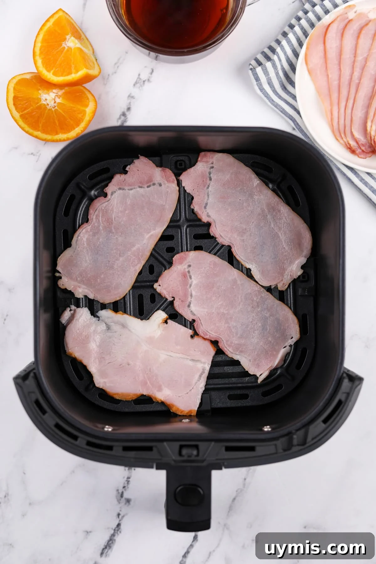 Air Fryer Canadian Bacon Breakfast Slices 4 An air fryer basket with Canadian bacon slices inside.