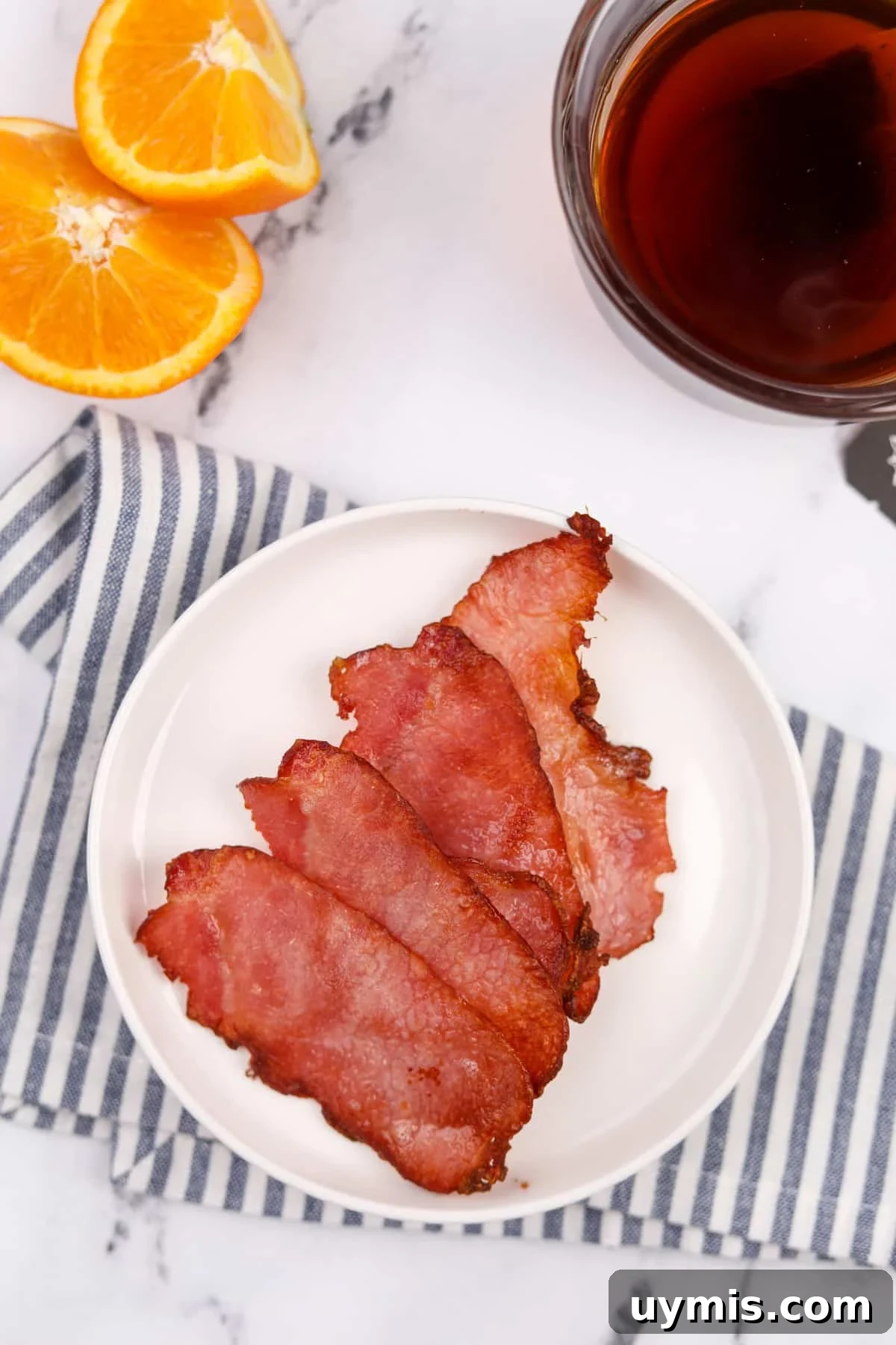 Air Fryer Canadian Bacon Breakfast Slices 7 A white plate with four cooked slices of back bacon.
