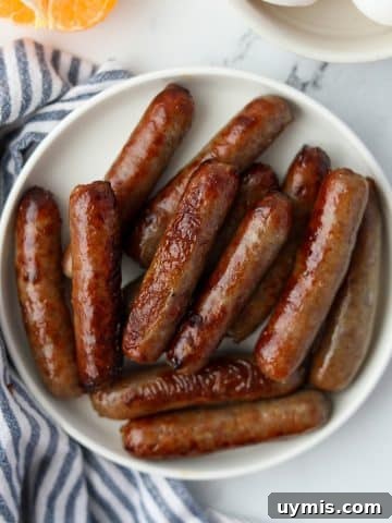 A small plate filled with cooked breakfast sausages.